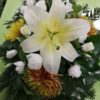 Koporsódísz, hosszúkás alakú, fehér liliom, fehér liziantusz, bronz színű krizantém, borostyánnal díszítve.