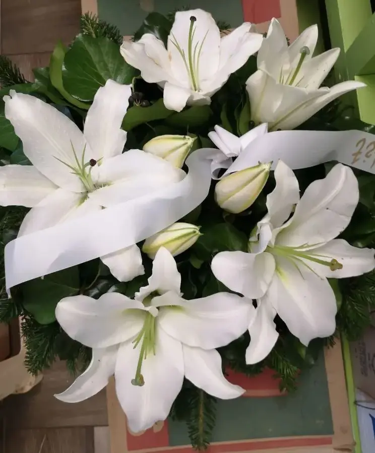 A sírcsokor kb.50cm, vizes oázisban díszített, fehér liliom felhasználásával