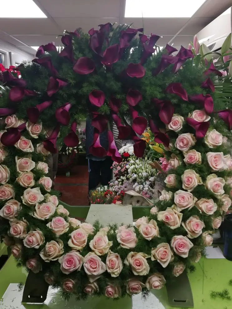 Álló görög koszorú (~1 m) pink kálával és halvány rózsaszín ekvádori rózsával – gyengéd, elegáns temetési kompozíció. Több színben rendelhető. Nefelejcs Virágüzlet.
